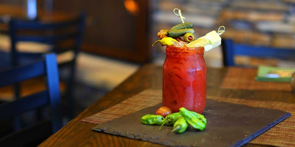Bloody mary cocktail with peppers, pickles, bacon and cheese.