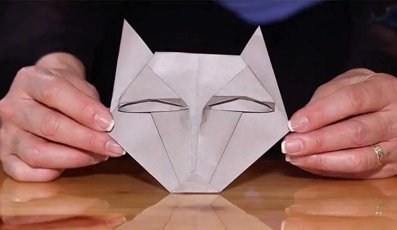 hands holding folded wolf origami