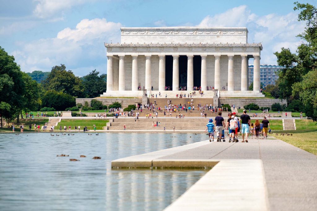Tourists at the National Mall in Washington D.C. with a view of the Lincoln Memorial and the World War Two Memorial