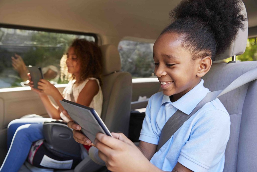 Children Using Digital Devices On Car Journey