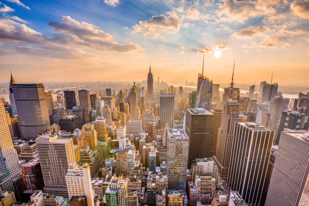 New York City skyline as the sun sets behind the buildings.