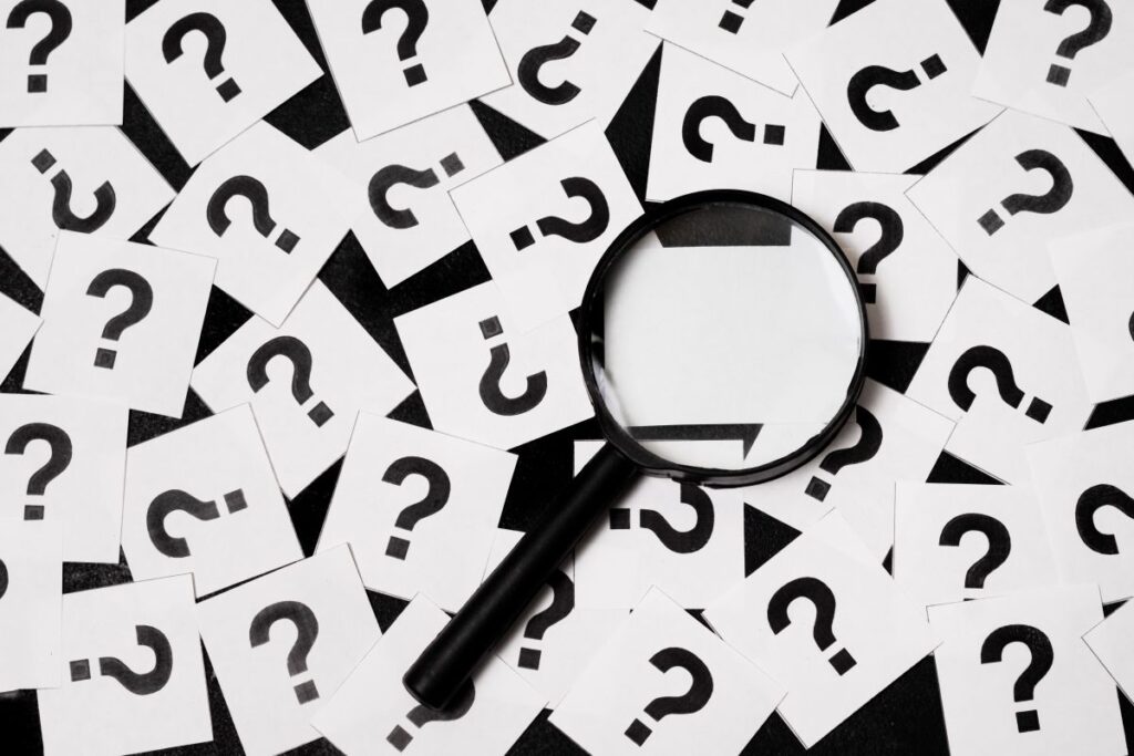 Question marks and magnifying glass